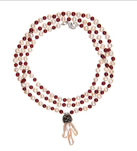 Dynamic combination of warm, passionate, deep red burgundy garnet round stones and freshwater pearls inspired the title: Deep Love. And as with love it can't be without that 'special touch'. In this case it is a charm made of brass and organic shape keishi pearl. You can wear it as a long single necklace, usual length double or choker style triple necklace.