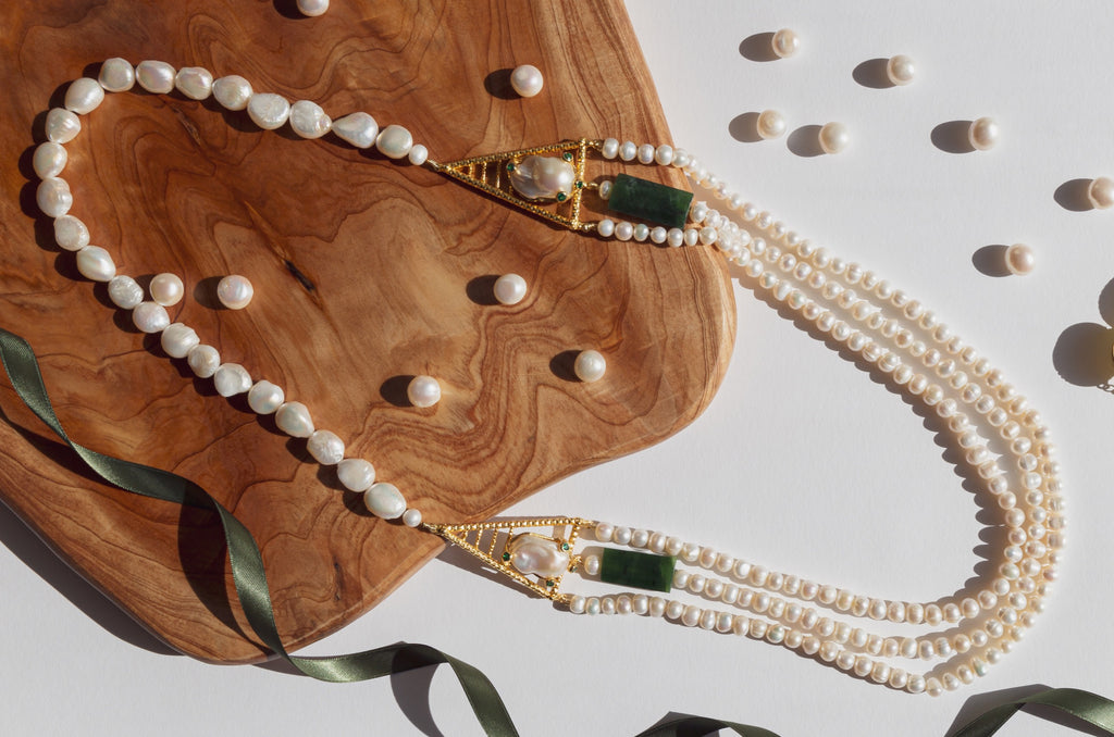 Joyful blend of historical references in its aesthetic is what makes this necklace unique. Freshwater pearls empowered with strong and significant green jade elements and gold plated silver cast that embraces the baroque pearl with a touch of four pieces of sparkling green topaz